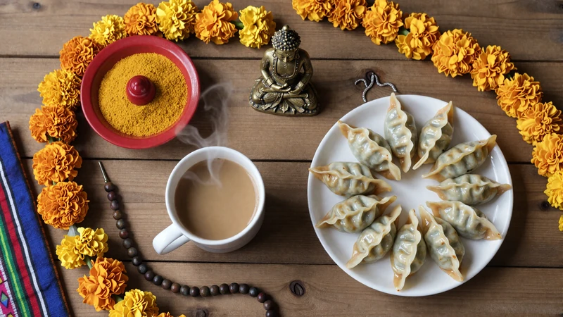 Nepali cultural items including chiya tea marigold garlands tika plate momos and prayer beads representing Nepali dating traditions